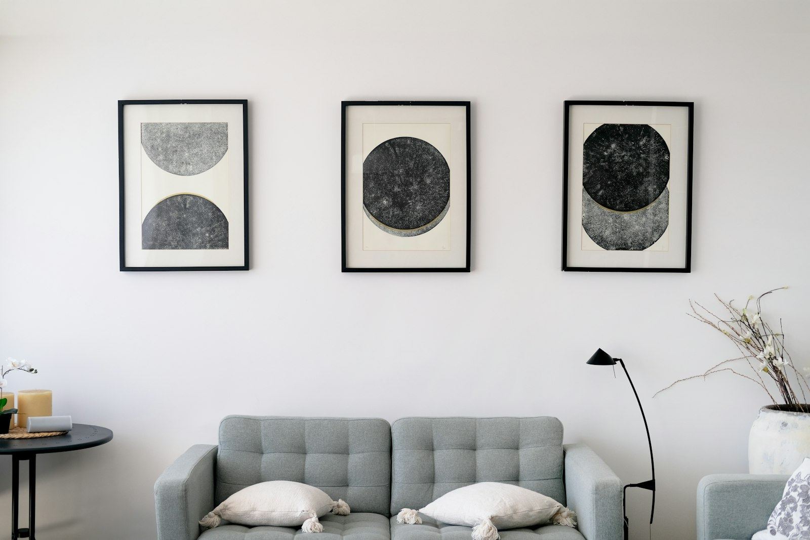 A living room with a grey sofa and three framed prints on the wall